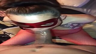 Hooded stunner is dressed in a crimson, fishnet costume while providing a deep throat to a insatiable stranger